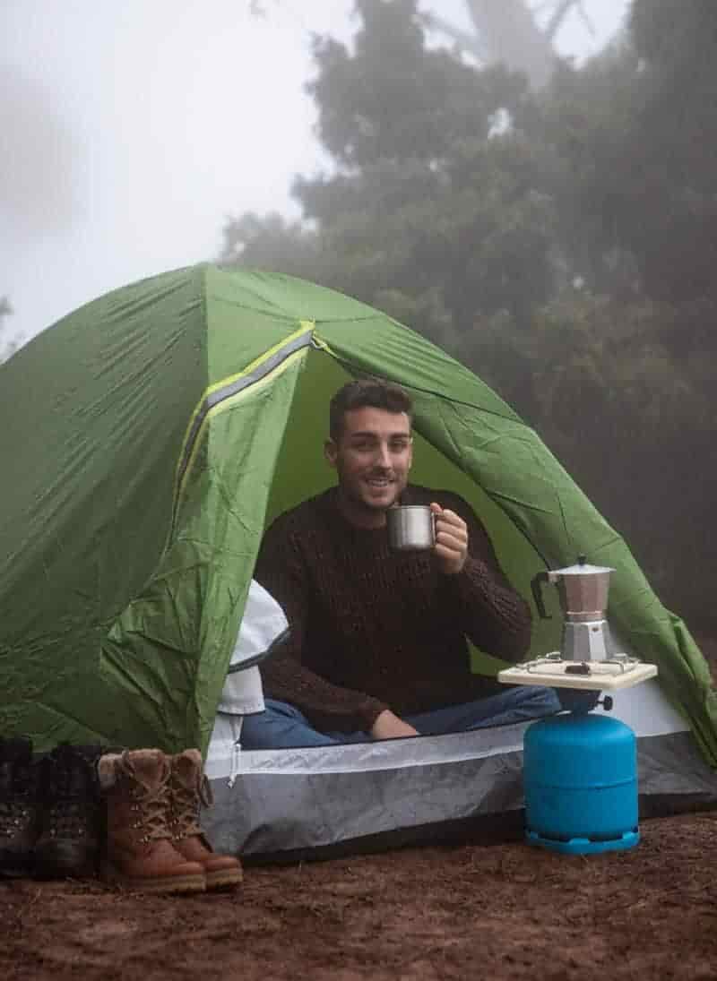 cooking at tent door while camping in the rain